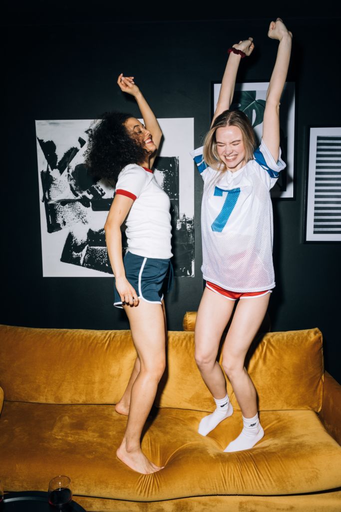 girls jumping on a couch and smiling