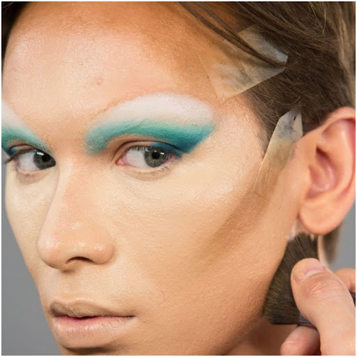 Miss Fame using a dense angled brush to contour