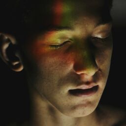 Man with eyes closed and prism light makeup over his face