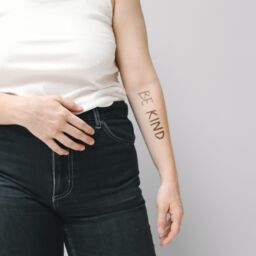 A woman with Be Kind written on her arm